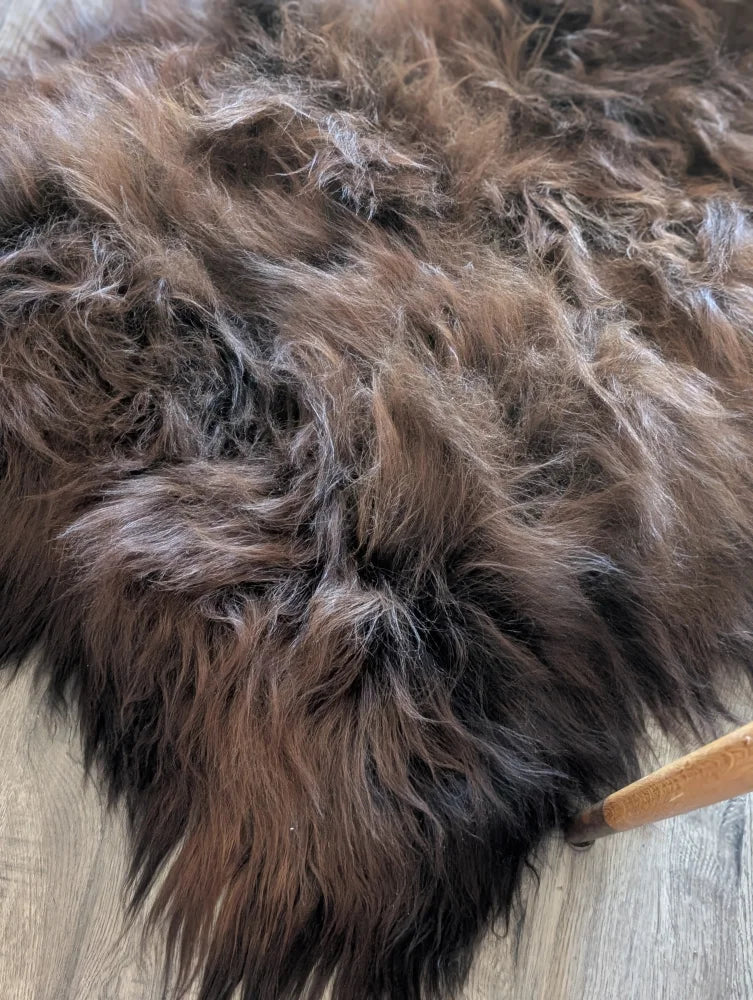 A plush shaggy brown and black icelandic sheepskin rug with soft textured wool icelandic fur perfect for cozy decor