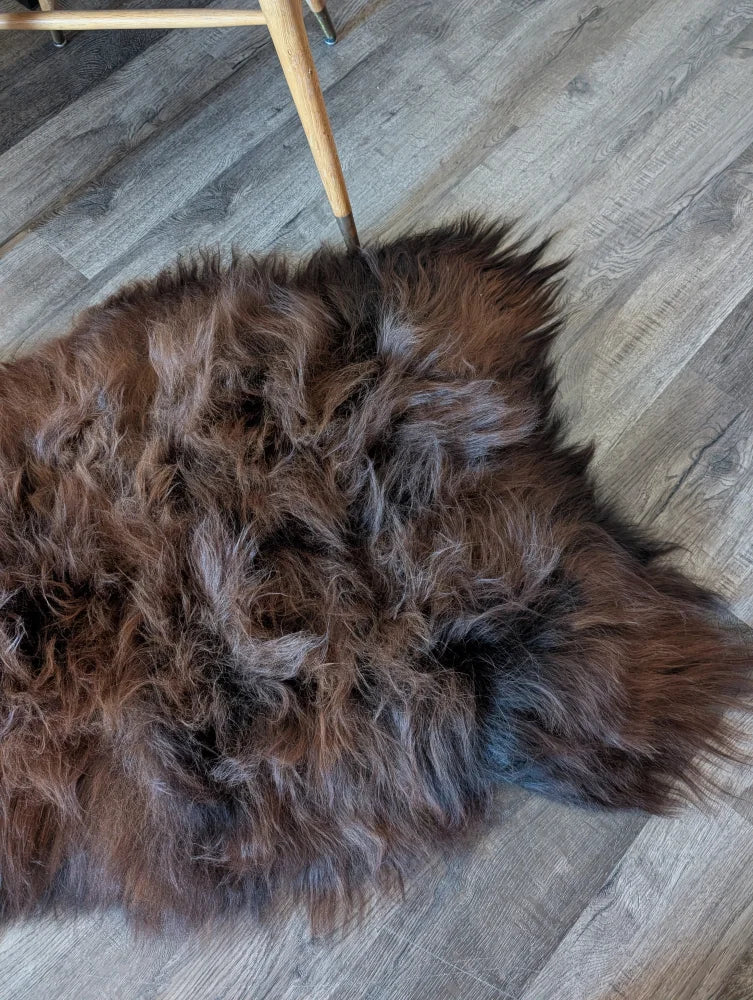 A plush irregular brown icelandic sheepskin rug with thick wool icelandic texture and natural shade variations