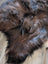A plush shaggy brown and black wool icelandic sheepskin rug with a soft textured surface perfect for cozy spaces