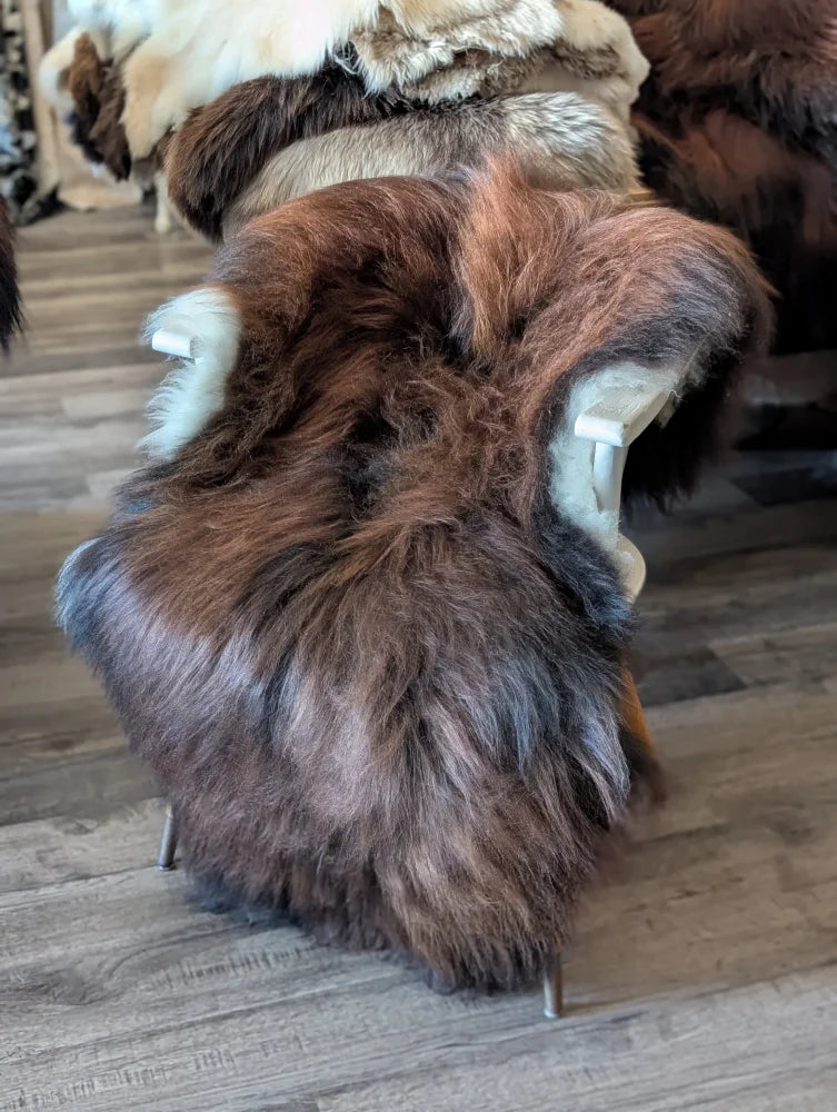 Brown and black icelandic sheepskin rug back side with white clips on wooden floor in wool icelandic style