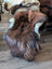 Brown and black icelandic sheepskin rug back side with white clips on wooden floor in wool icelandic style