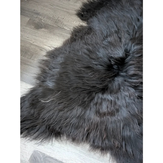 Massive 59x32 black Icelandic sheepskin rug on wood floor