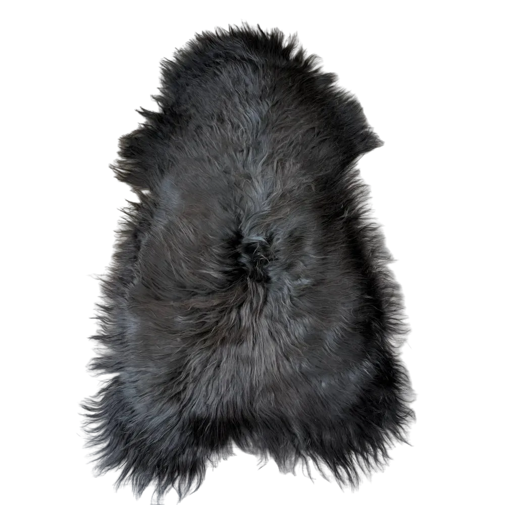 Black icelandic sheepskin rug with dense long fur and natural irregular shape perfect for cozy decor