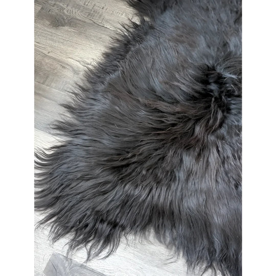 Massive 57x32 black Icelandic sheepskin rug with soft, thick fur on wood floor