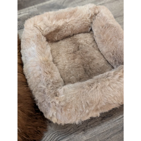 Cozy beige sheepskin pet bed with plush faux fur lining