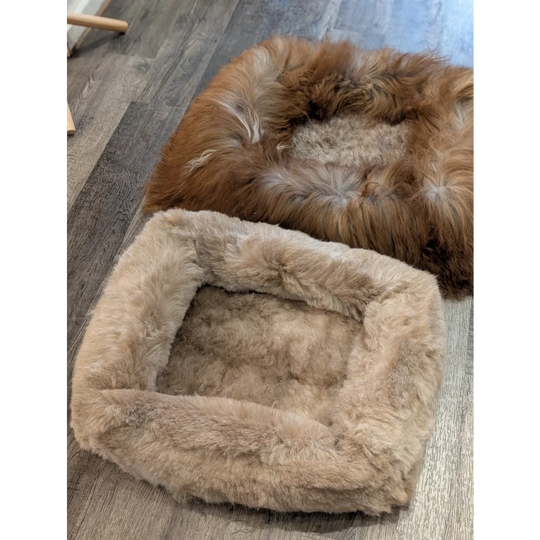 Cozy tan faux fur sheepskin pet bed with plush interior and rounded corners