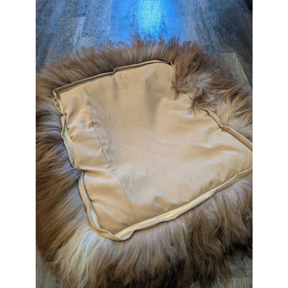 Cozy highland sheepskin pet bed with cream fur throw and brown accents