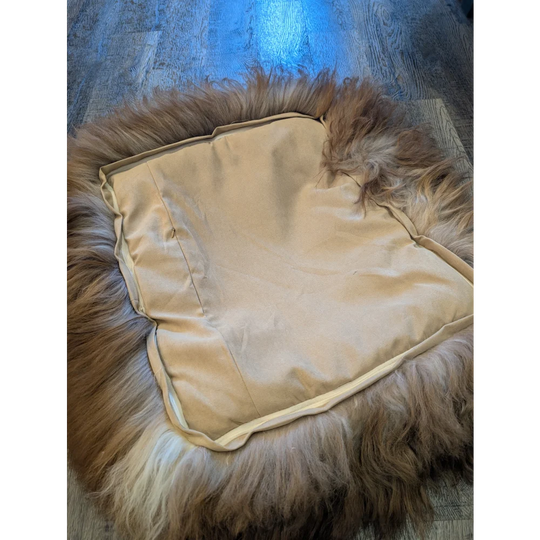 Cozy highland sheepskin pet bed with cream fur throw and brown accents