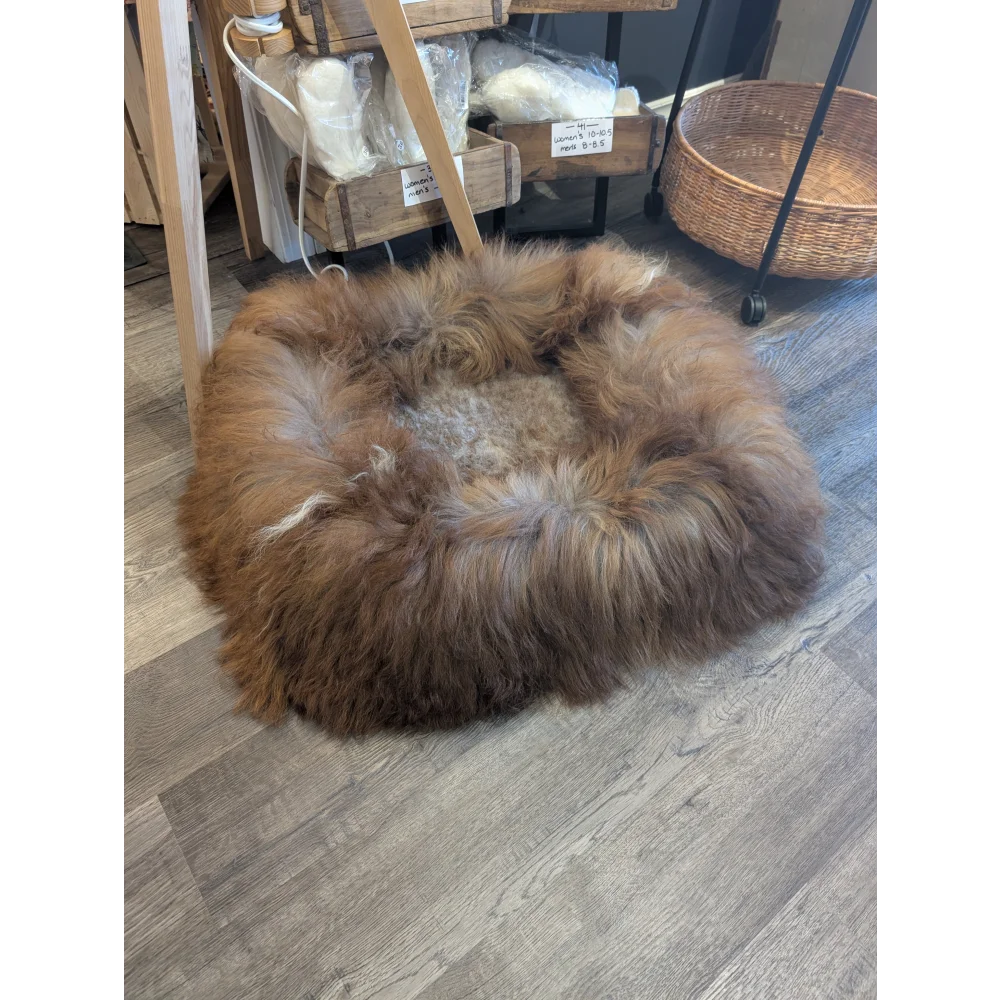 Cozy round highland sheepskin pet bed with brown tan fur