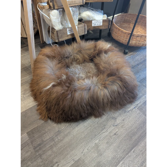Cozy round highland sheepskin pet bed with brown tan fur
