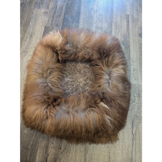 Cozy faux fur sheepskin pet bed in warm brown tan tones