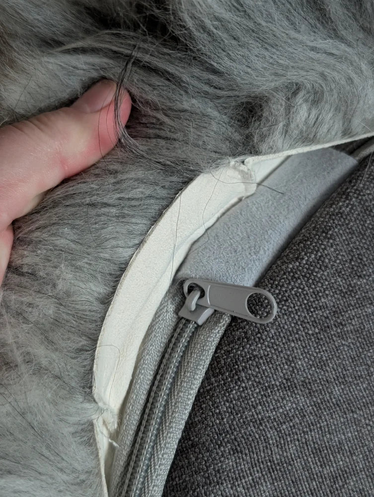 Gray faux fur zipper pull on Icelandic sheepskin floor pouf