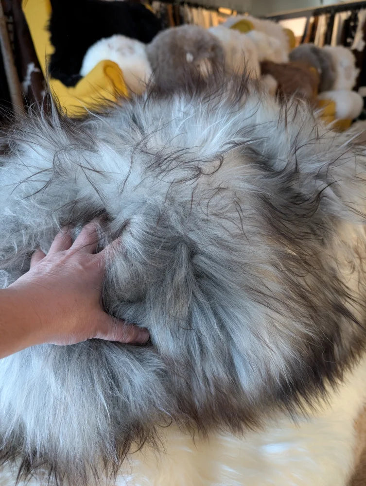 Fluffy grey Icelandic sheepskin floor pouf with soft faux fur texture