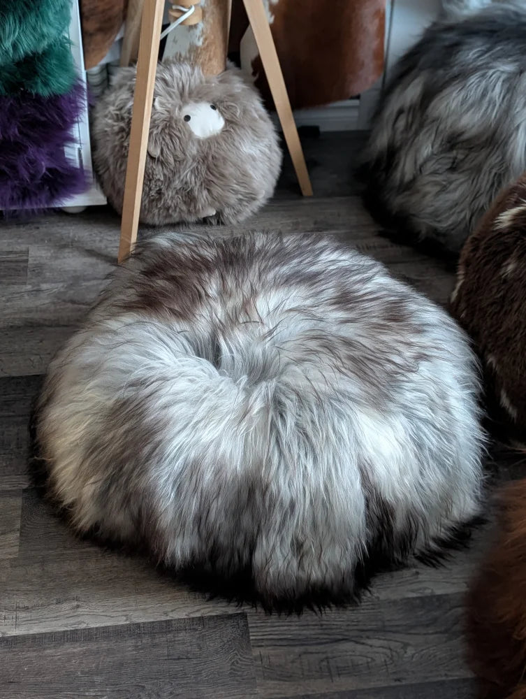 Fluffy gray white Icelandic sheepskin floor pouf with dark base