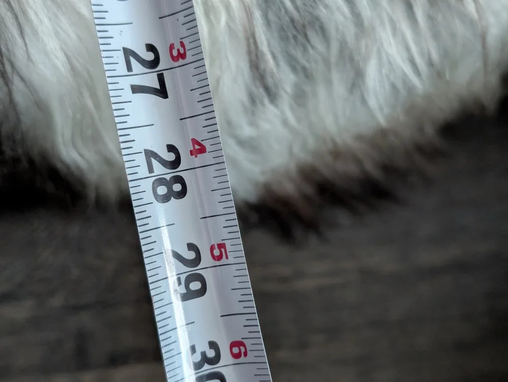 White measuring tape on grey Icelandic sheepskin floor pouf