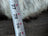 White measuring tape on grey Icelandic sheepskin floor pouf