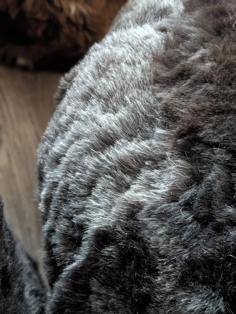 Plush curly-furred Icelandic sheepskin floor pouf in wolf gray