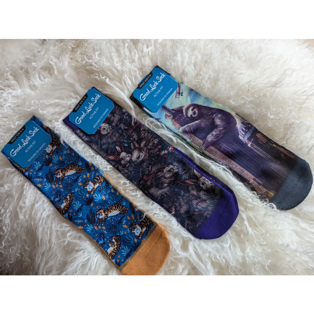 Three pairs of cat-themed socks with different feline designs in blue and purple tones.