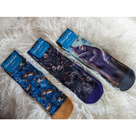 Three pairs of cat-themed socks with different feline designs in blue and purple tones.