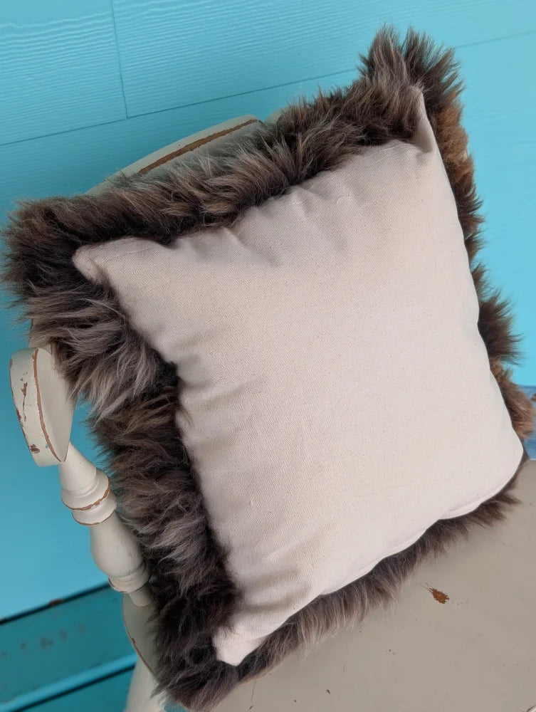 Beige british sheepskin cushion with plush dark brown faux fur trim made from unbleached cotton canvas by angus oliver