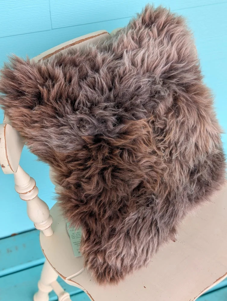 A plush shaggy brown british sheepskin cushion with soft faux fur on unbleached cotton canvas by angus oliver