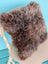 A plush shaggy brown british sheepskin cushion with soft faux fur on unbleached cotton canvas by angus oliver