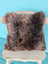 Fluffy medium-length brown british sheepskin cushion with soft natural texture on unbleached cotton canvas angus oliver