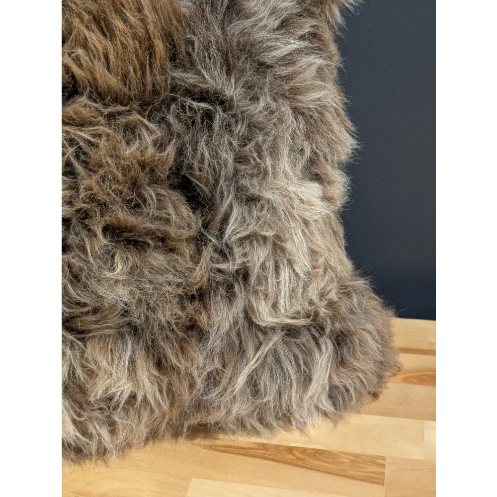 Gorgeous british sheepskin cushion with plush shaggy gray and brown fur on unbleached cotton canvas backing