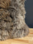 Gorgeous british sheepskin cushion with plush shaggy gray and brown fur on unbleached cotton canvas backing