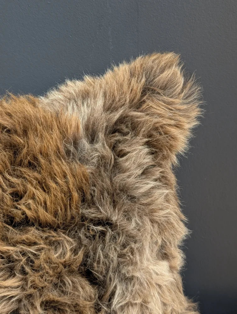Gorgeous british sheepskin cushion with plush natural texture in brown beige tones on soft unbleached cotton canvas