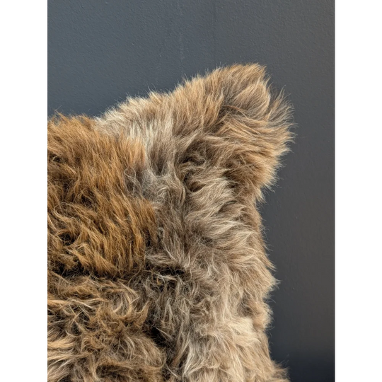 Gorgeous british sheepskin cushion with plush natural texture in brown beige tones on soft unbleached cotton canvas