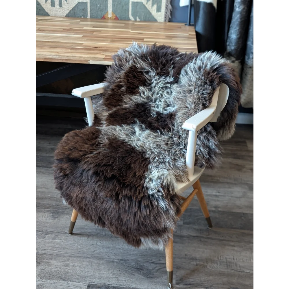 Gorgeous fluffy British sheepskin chair cover with natural spotted brown gray fur and wooden legs