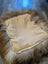 Cozy highland sheepskin pet bed with cream fur throw and brown accents