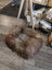 Cozy highland sheepskin pet bed with brown wool rug, wood legs, metal base