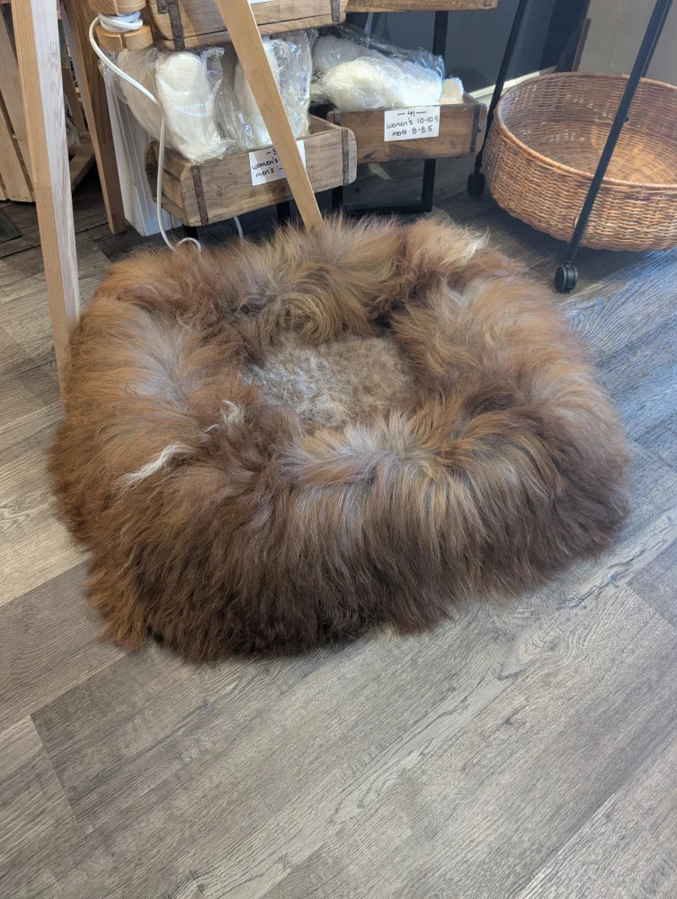 Cozy round highland sheepskin pet bed with brown tan fur