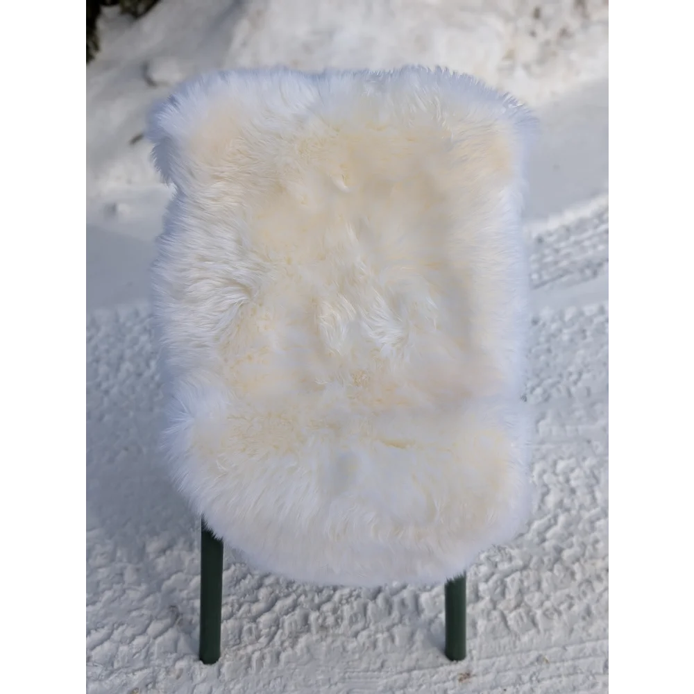 Gorgeous Merino sheepskin rug on green legs, OEKO-TEX certified, snowy backdrop