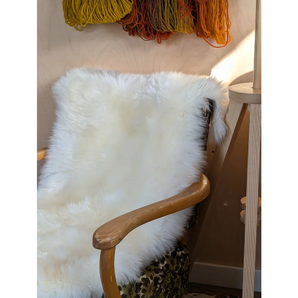 White fluffy Merino sheepskin throw on chair arm, OEKO TEX certified