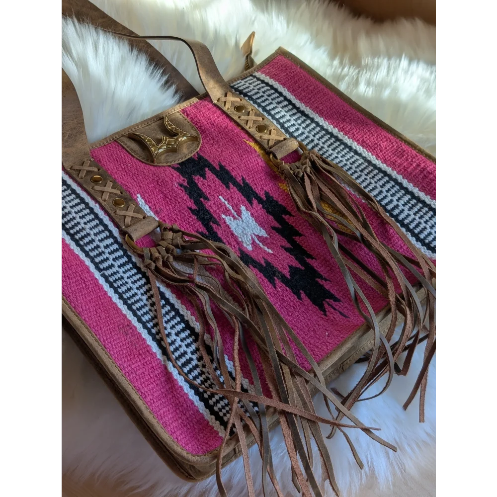 Gorgeous wool and leather bag with vibrant pink wool, black and white geometric pattern, hand-tooled leather accents, and tan fringes