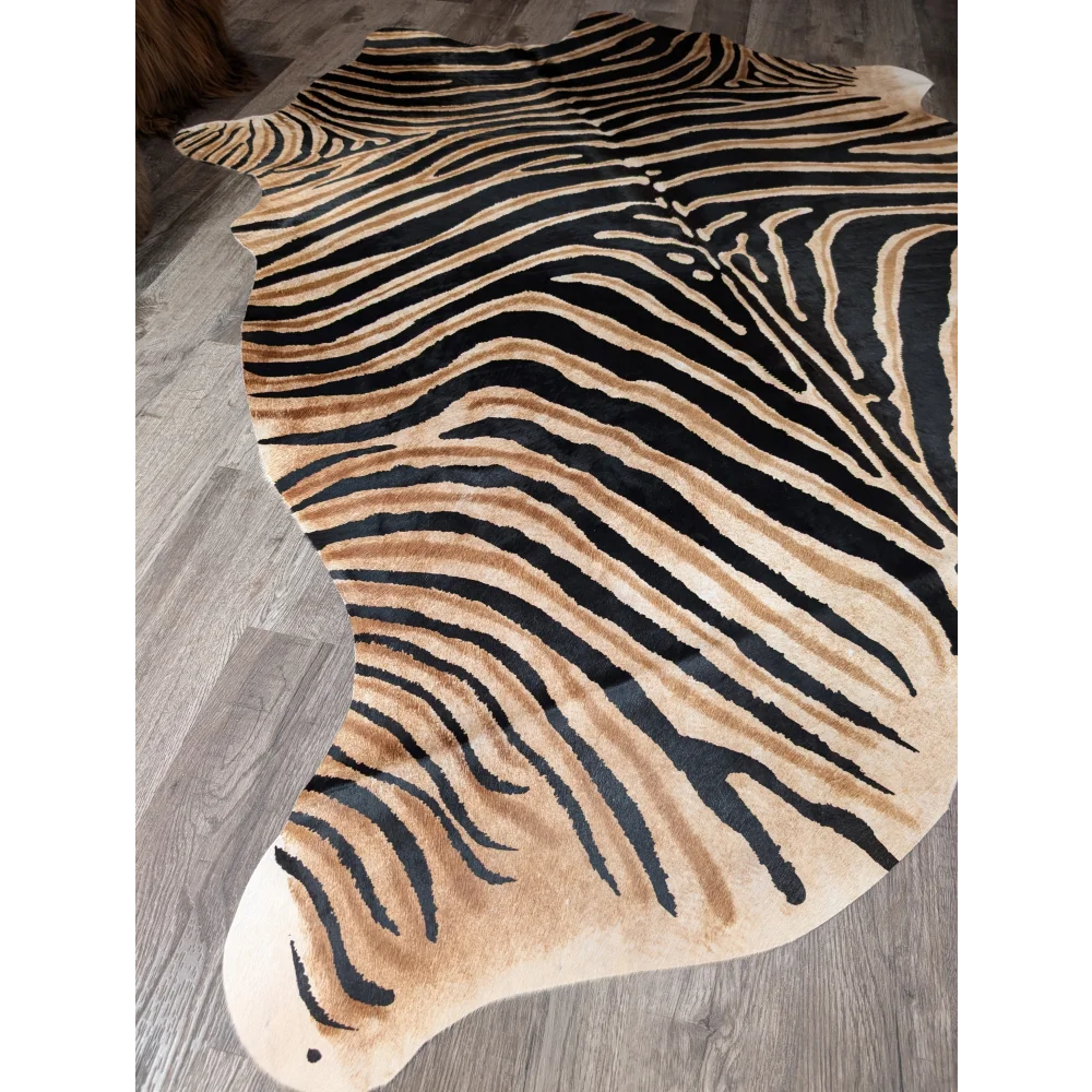 A gorgeous zebra printed large cowhide rug by angus oliver featuring plush faux fur with unique black and tan stripes