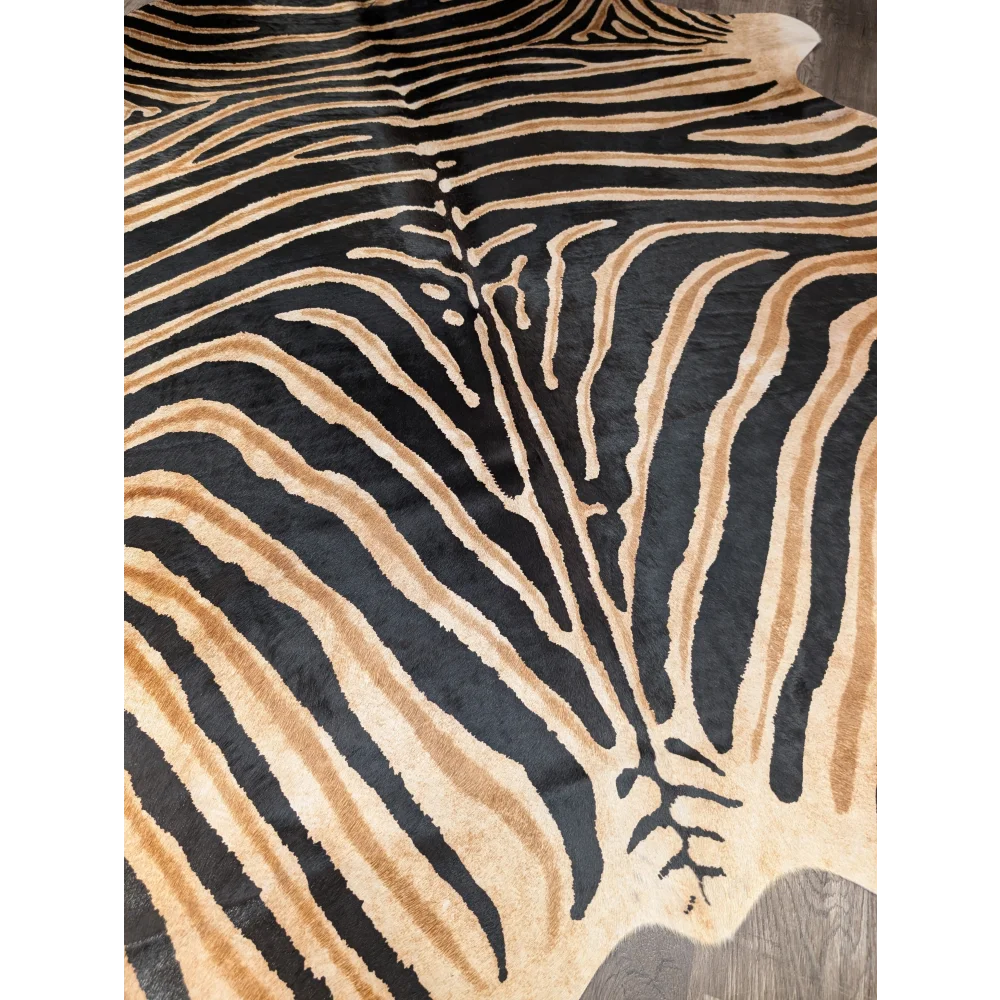 A plush large cowhide rug by angus oliver with bold black and tan zebra print unique characteristics