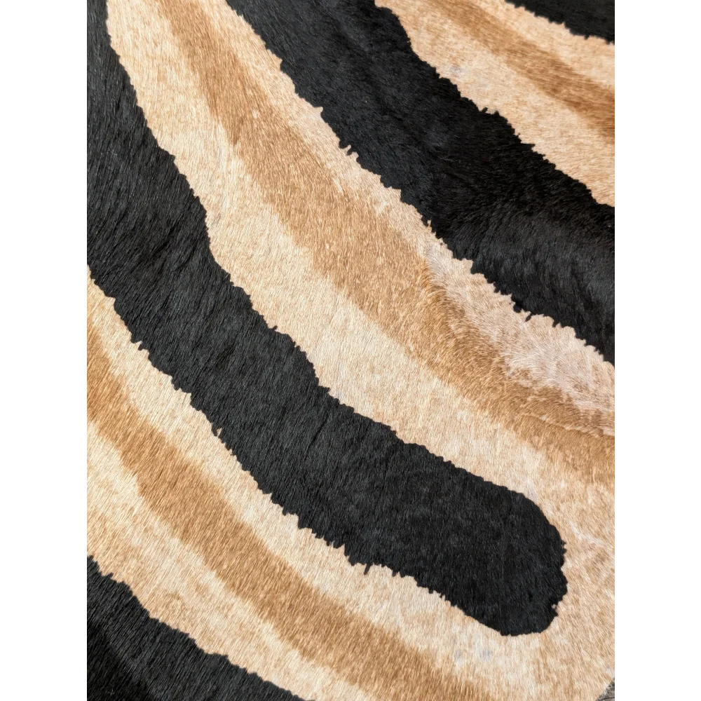 Plush faux leather large cowhide rug with bold black and tan zebra stripes showing unique characteristics by angus oliver