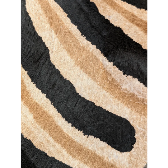 Plush faux leather large cowhide rug with bold black and tan zebra stripes showing unique characteristics by angus oliver