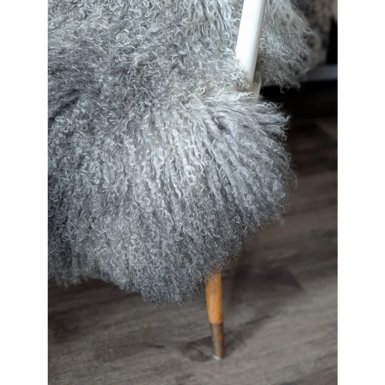 Gotland sheepskin 52x31 grey fluffy throw on white frame chair