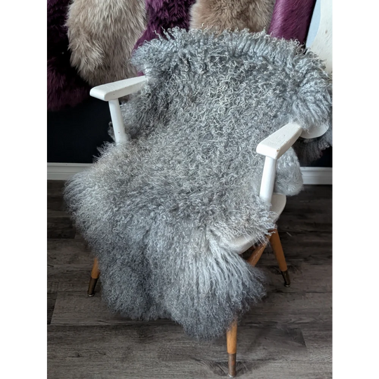 Cozy gray Gotland sheepskin throw on wooden chair from Oliver Luxury Sheepskins