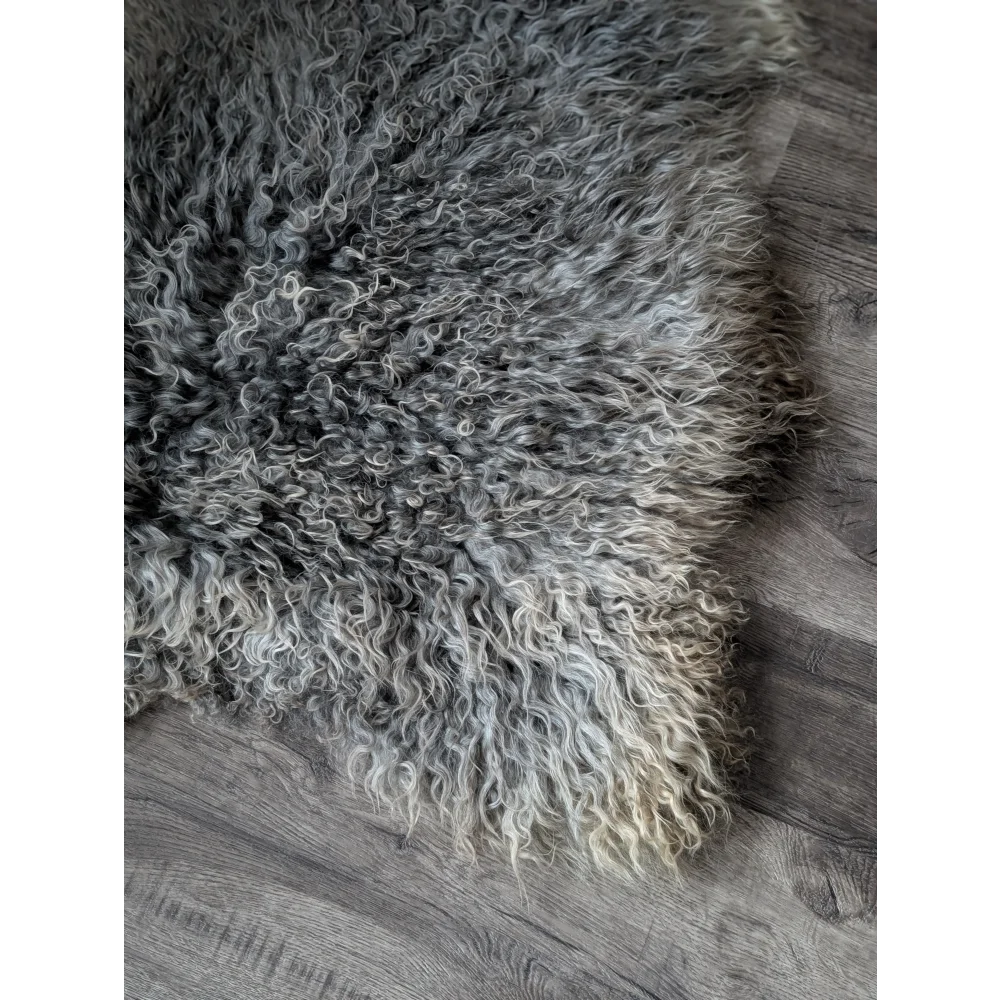 Gray and white curly Gotland sheepskin rug, 44x30 inches, on wooden floor