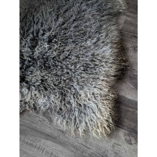 Gray and white curly Gotland sheepskin rug, 44x30 inches, on wooden floor