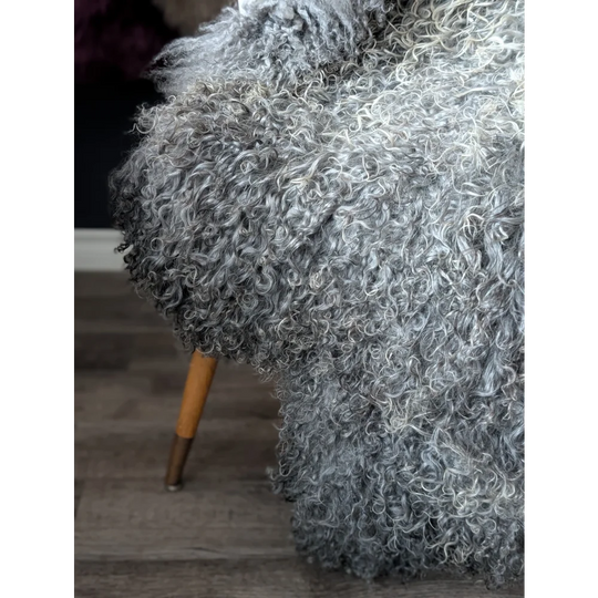 Grey fluffy dog with wooden legs on Oliver Luxury Sheepskins gotland sheepskin 52x31