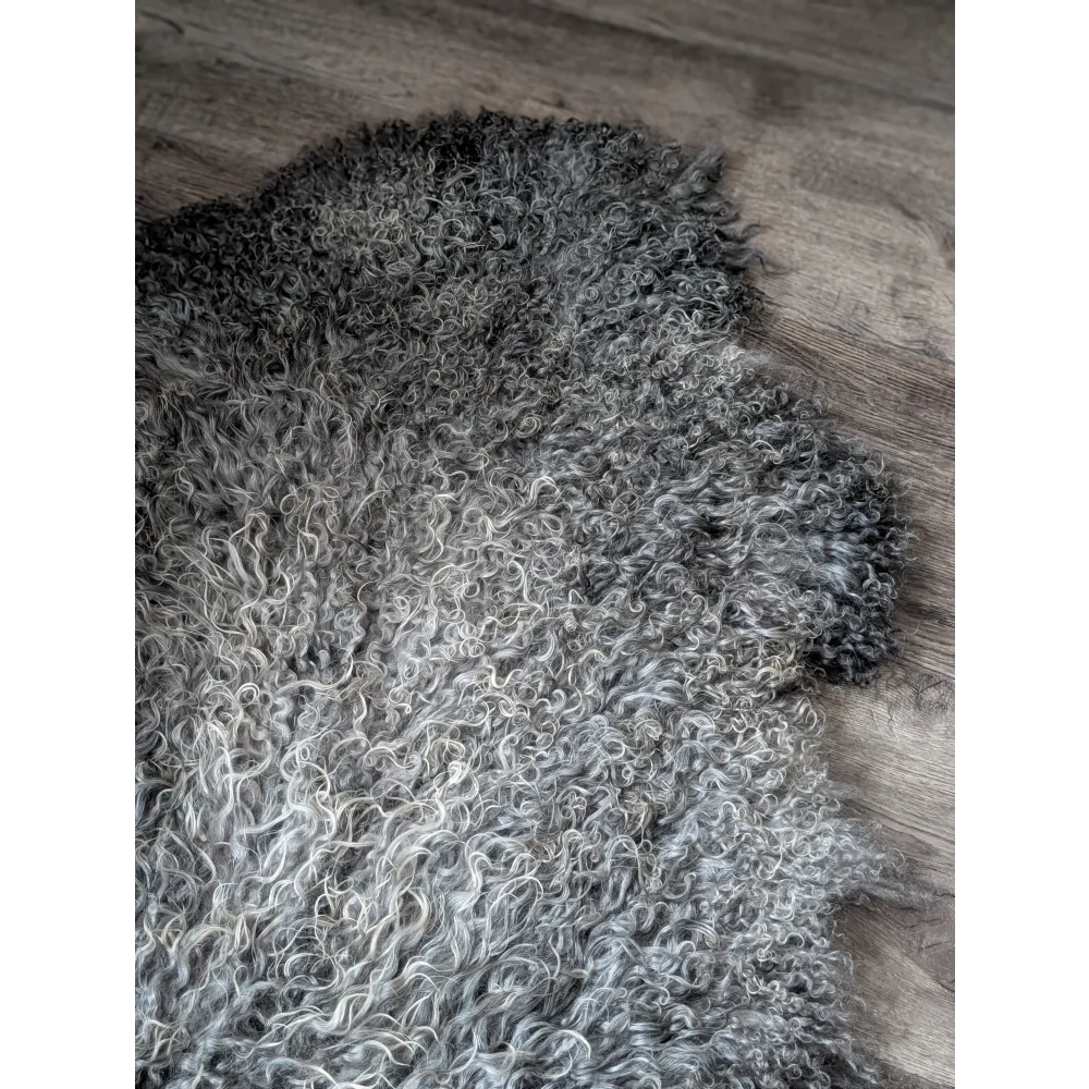 Gray and white curly Gotland sheepskin rug, 52x31, on wooden floor