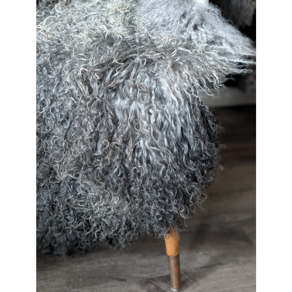 Grey fluffy Gotland sheepskin ottoman with wooden legs, 52x31