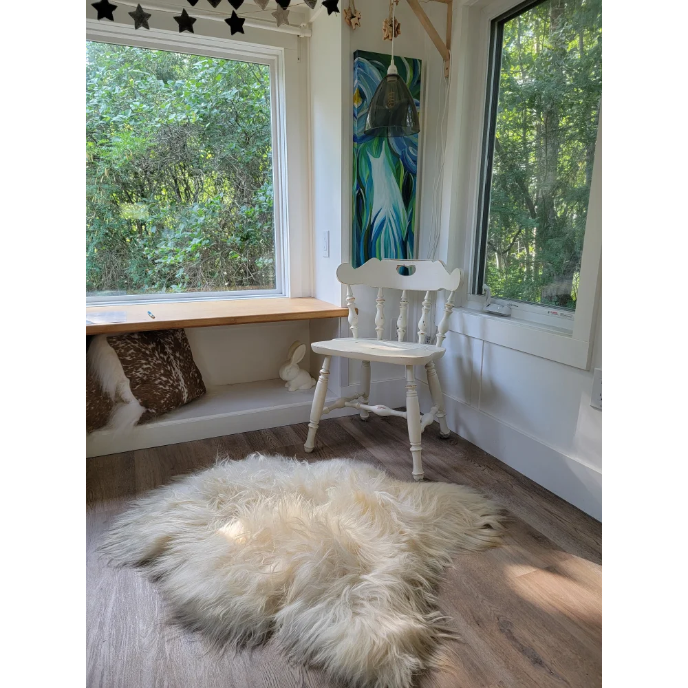 White wooden chair with spindle back and turned legs featuring a soft icelandic sheepskin rug 53x34 inches